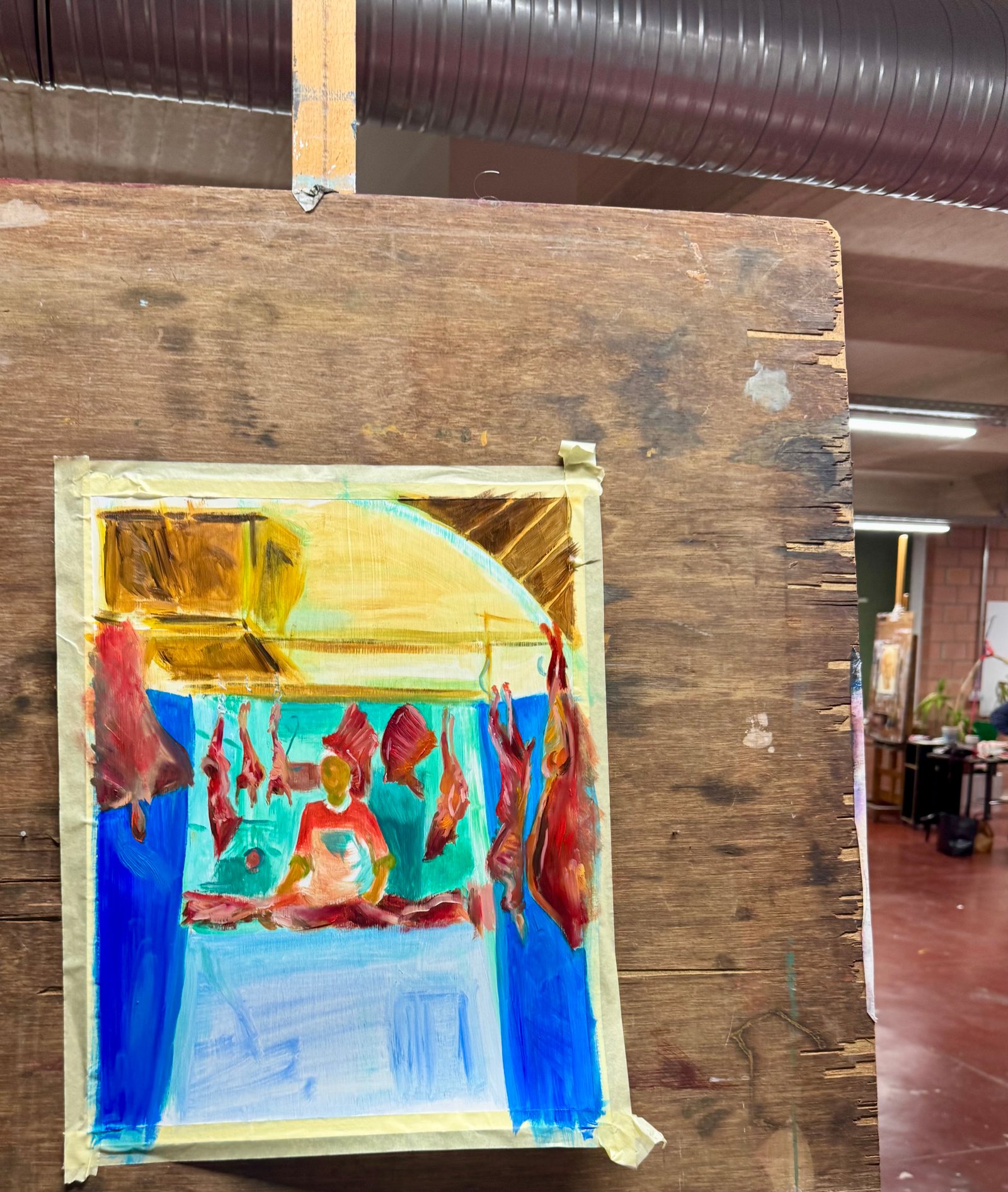 Schilderij in uitvoering in het atelier — een figuur zittend in rood, omringd door hangende rode vormen, blauwe en turquoise achtergrond, gele boog erboven.
