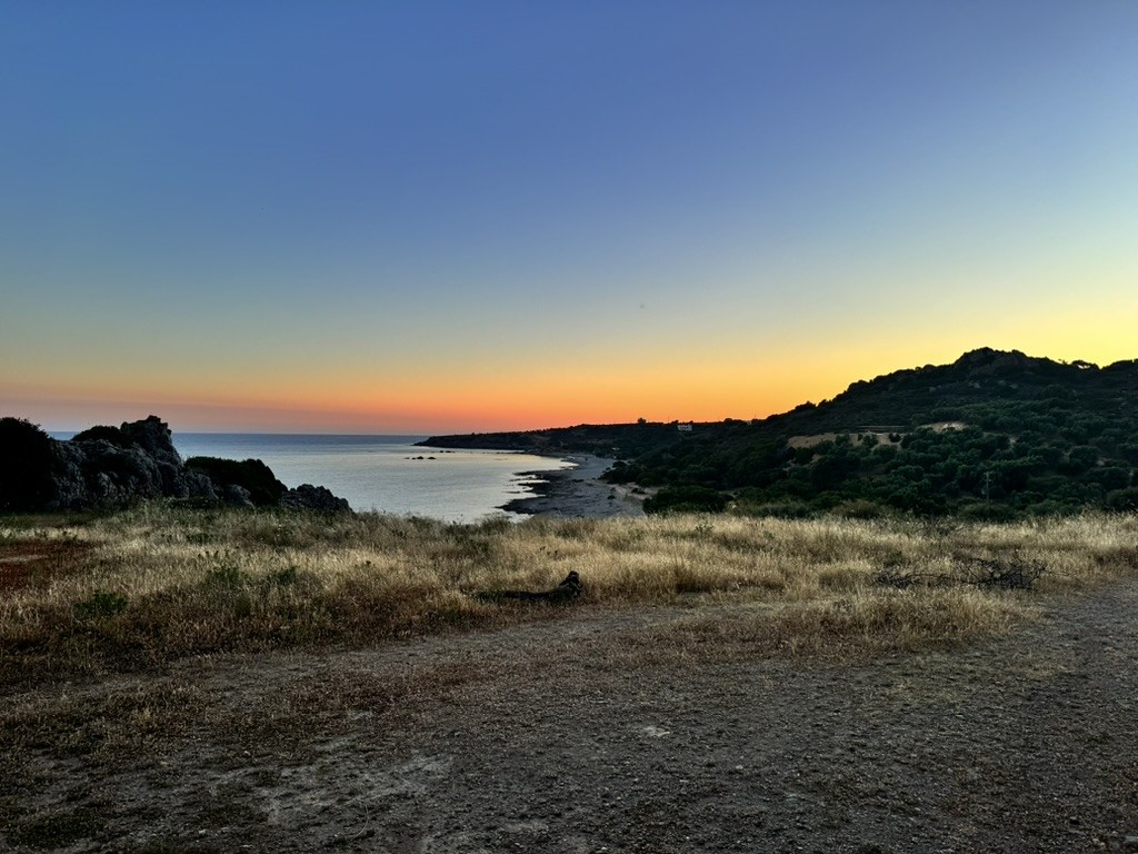 Zonsondergang over zee met bergsilhouet